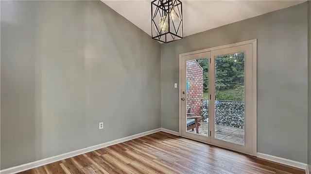 a view of an empty room with wooden floor and balcony