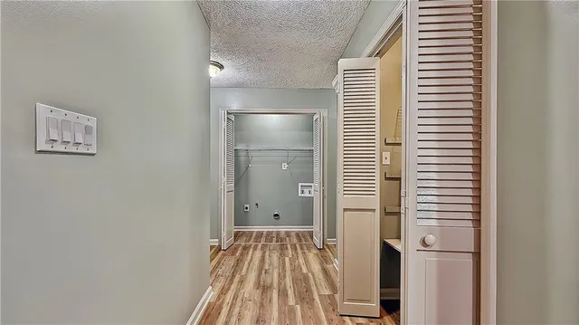 a view of a hallway with wooden floor and closet