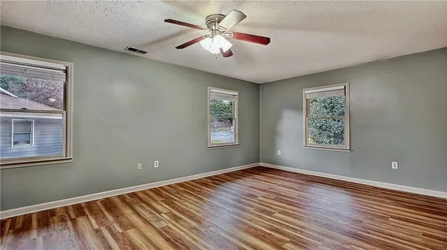 a view of a room with wooden floor and a ceiling fan