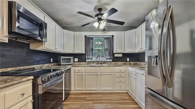 a kitchen with stainless steel appliances granite countertop a stove sink and cabinets