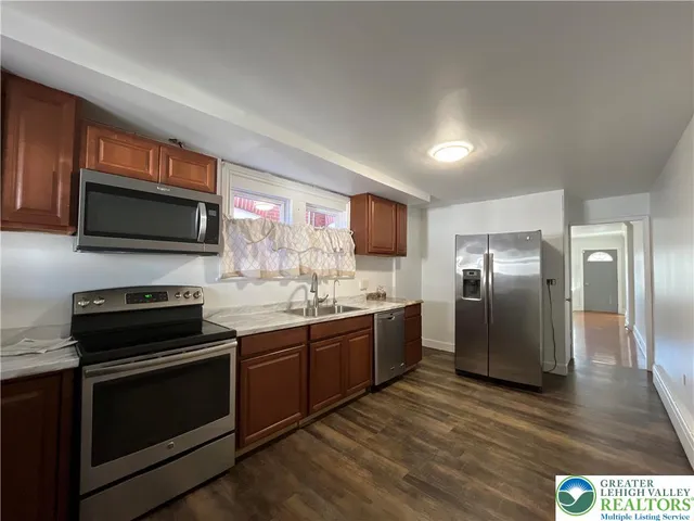 a kitchen with stainless steel appliances granite countertop a stove microwave and refrigerator