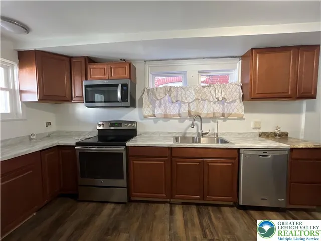 a kitchen with stainless steel appliances granite countertop a sink stove and microwave