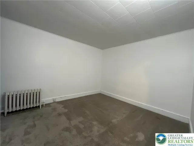 an empty room with mirror in hallway