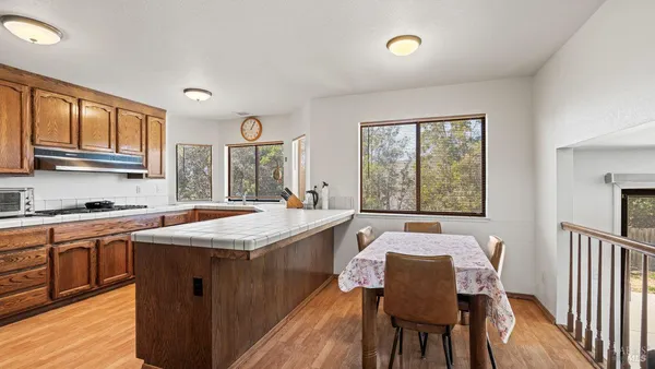 a kitchen with a stove a sink a dining table and chairs