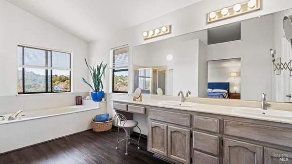 a bathroom with a double vanity sink a mirror and a bathtub