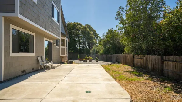 a view of backyard with table and chairs and wooden fence