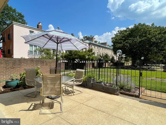 a view of a patio with a table and chairs under an umbrella