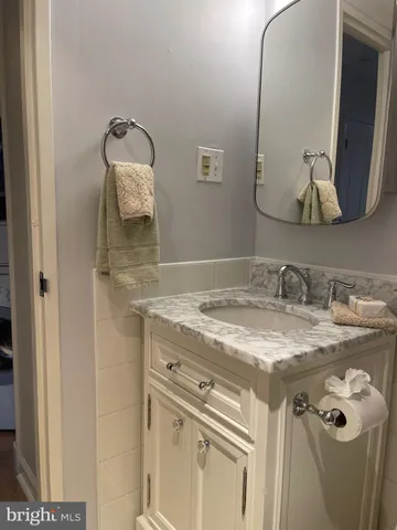 a bathroom with a granite countertop sink and a mirror