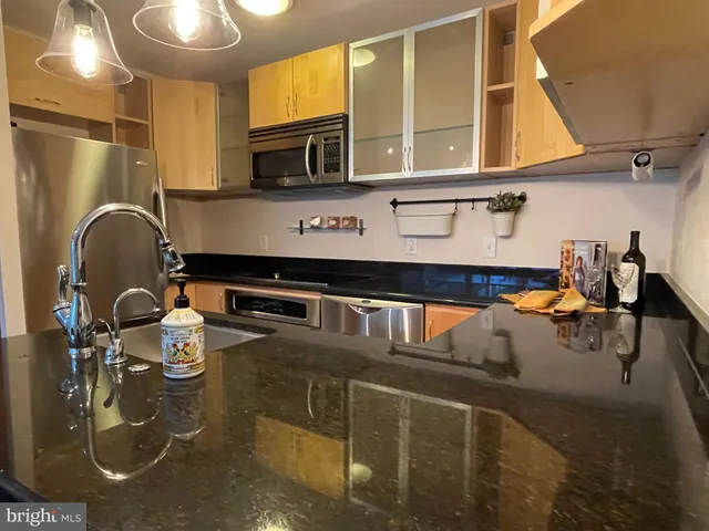 a kitchen with stainless steel appliances granite countertop a stove a sink and a microwave