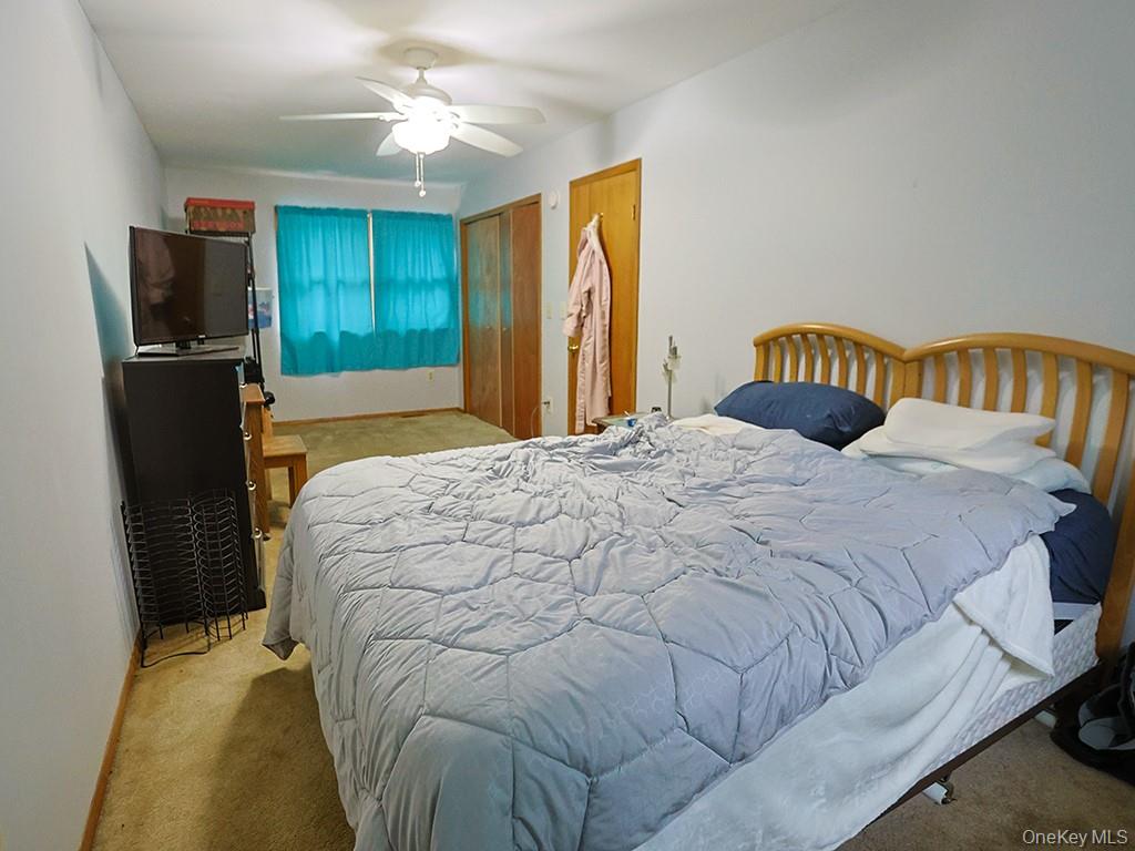 68 Kennel Road Cuddebackville, NY 12729 - Photo 18 of 21 a bedroom with a bed and a chandelier