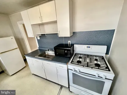 a stove top oven sitting inside of a kitchen