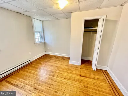 a view of an empty room with closet and a window