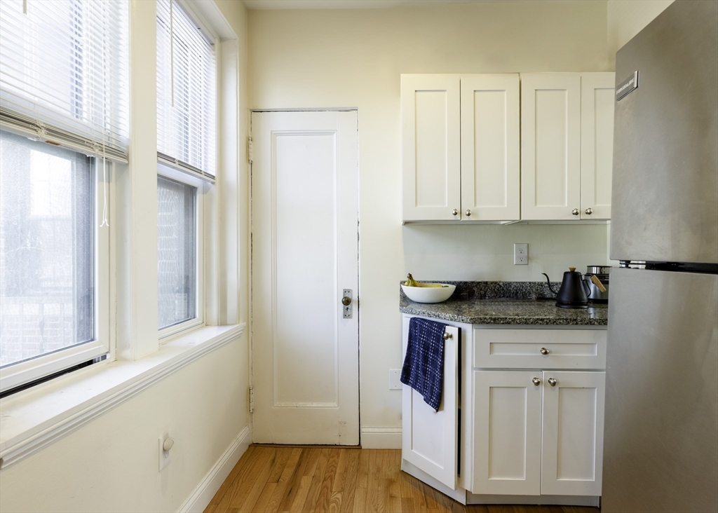 31 Winslow Road, Unit 3 Brookline, MA 02446 - Photo 3 of 10 a kitchen with stainless steel appliances granite countertop a stove and a refrigerator