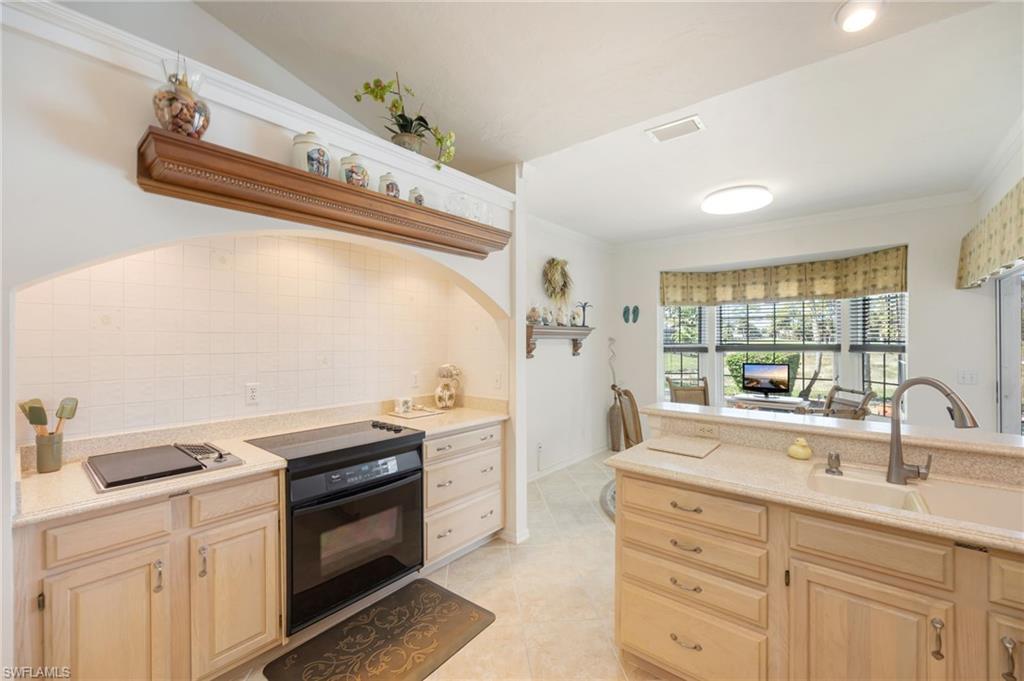 867 St Andrews Boulevard Naples, FL 34113 - Photo 12 of 28 a kitchen with a sink stove and cabinets
