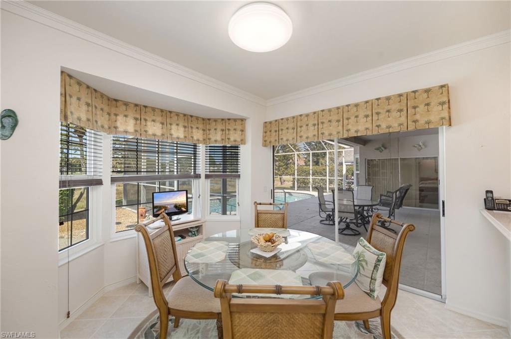 867 St Andrews Boulevard Naples, FL 34113 - Photo 13 of 28 a view of a dining room with furniture large windows and wooden floor