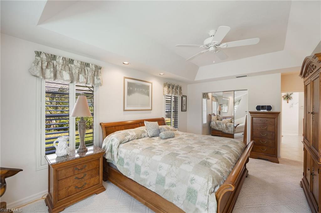 867 St Andrews Boulevard Naples, FL 34113 - Photo 16 of 28 a bedroom with a large bed and a chandelier