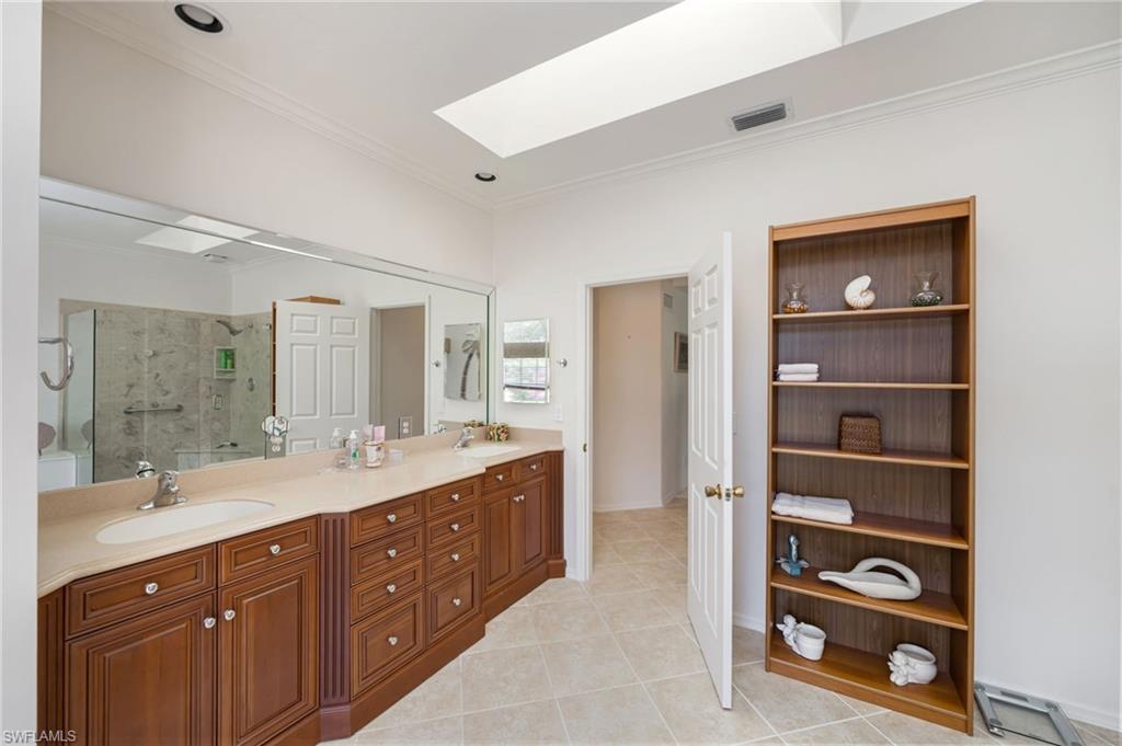 867 St Andrews Boulevard Naples, FL 34113 - Photo 18 of 28 a spacious bathroom with a double vanity sink and a mirror