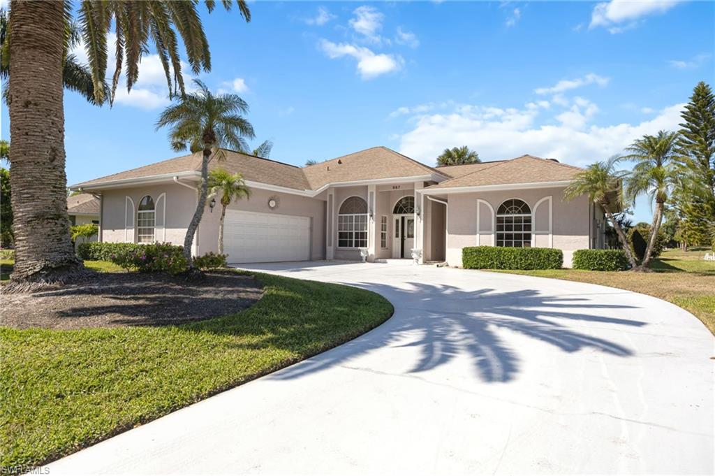 867 St Andrews Boulevard Naples, FL 34113 - Photo 2 of 28 a front view of a house with a garden