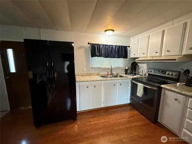 a kitchen with a refrigerator and a stove top oven