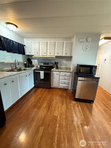 a large kitchen with stainless steel appliances granite countertop a stove a sink and a refrigerator