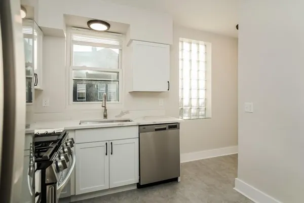 a kitchen with a sink cabinets appliances and a window