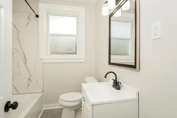 a bathroom with a toilet sink and mirror