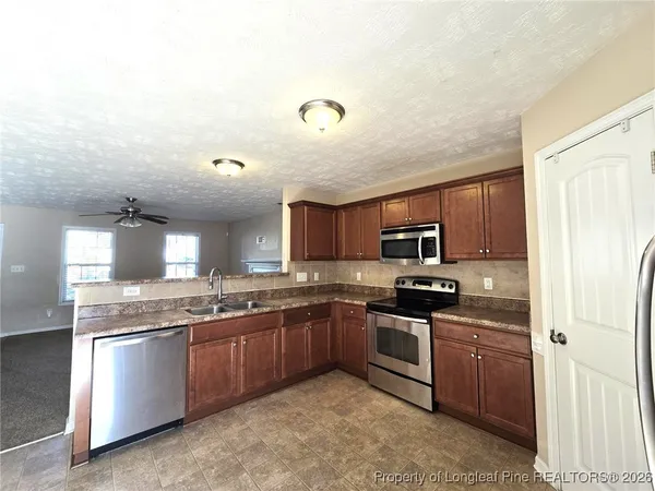 a kitchen with stainless steel appliances granite countertop a sink and stove top oven