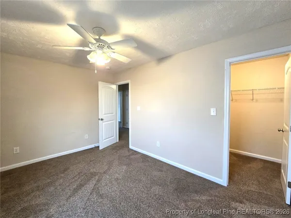 a view of an empty room and window with a fan