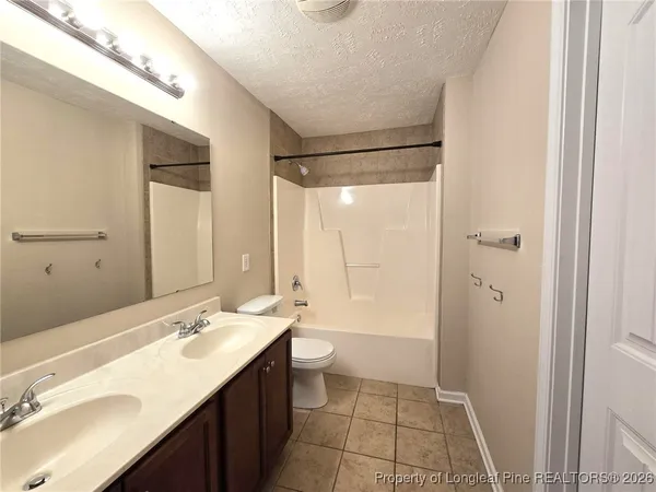 a bathroom with a double vanity sink toilet mirror and shower