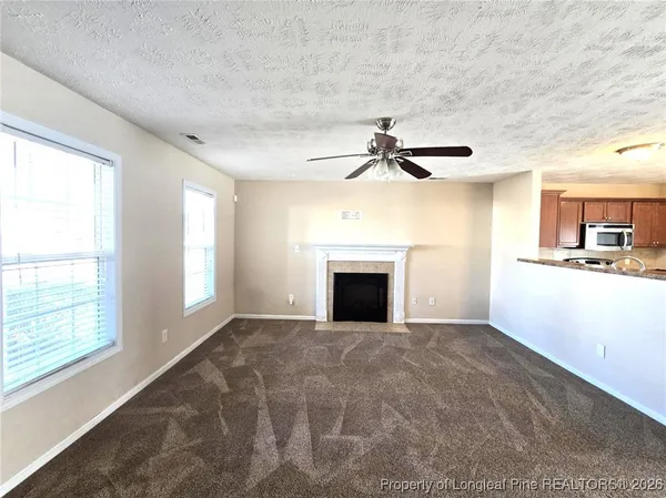 a view of empty room with windows and fireplace