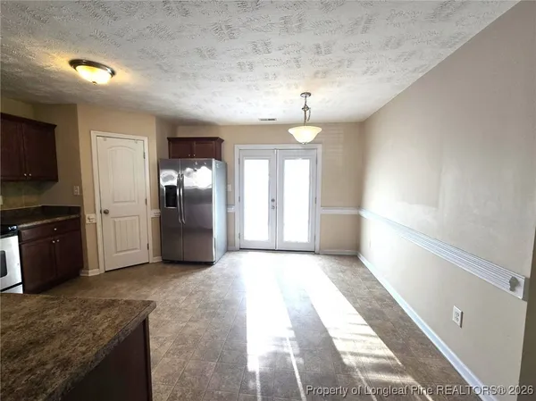 a large kitchen with a refrigerator and a sink