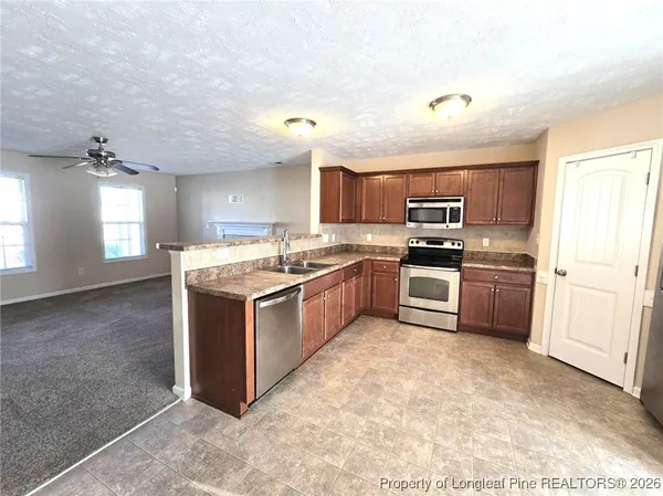a kitchen with stainless steel appliances granite countertop a stove top oven and cabinets