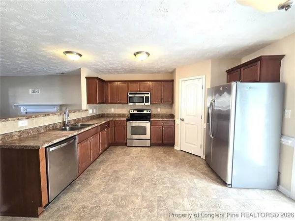 a large kitchen with cabinets and stainless steel appliances