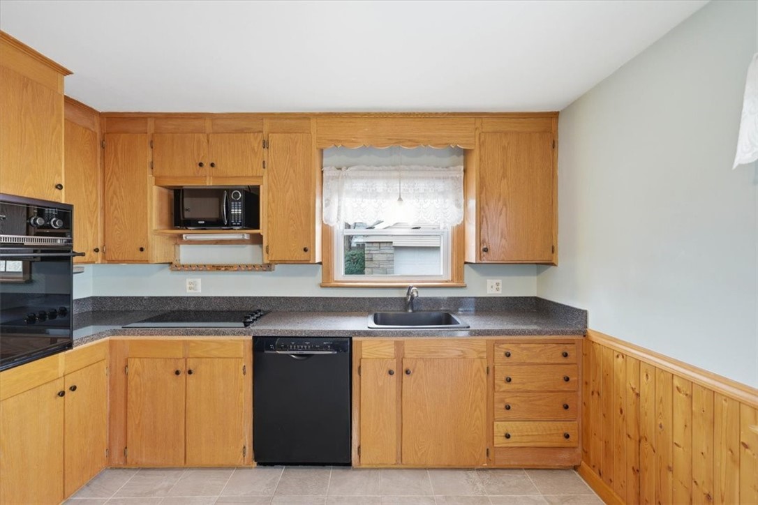 80 Maplecrest Drive Pawtucket, RI 02861 - Photo 16 of 44 Spacious eat-in kitchen featuring warm wood cabinetry, durable solid-surface countertops with an integrated sink, and abundant storage including built-in wall oven cabinetry.