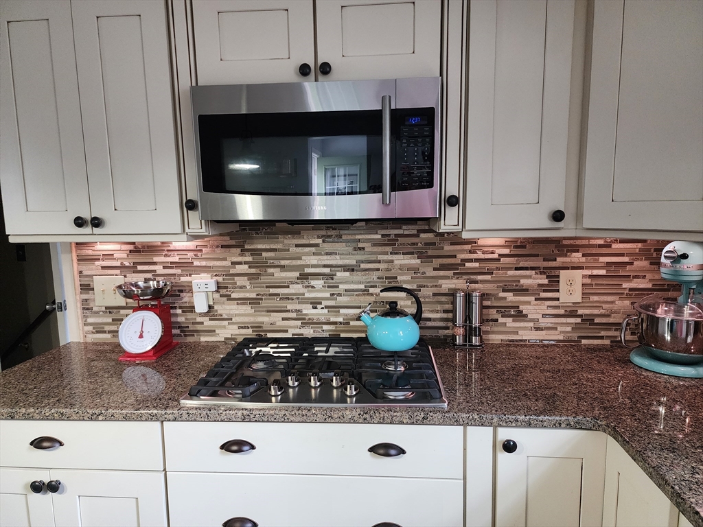 49 Edward Road Townsend, MA 01469 - Photo 7 of 41 a kitchen with a stove a microwave a sink and cabinets