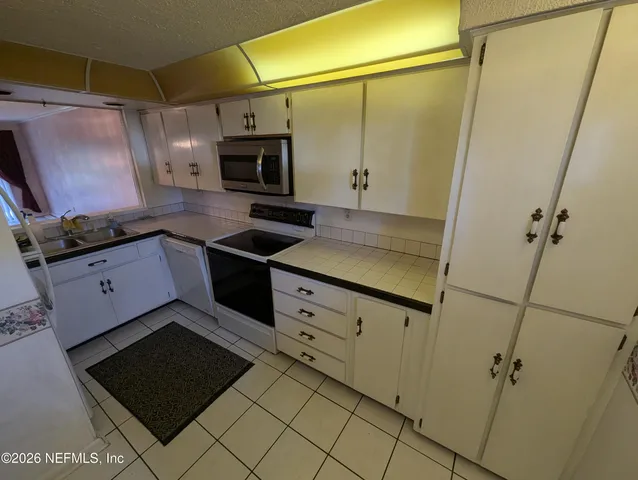 a kitchen with stainless steel appliances cabinets and a counter top space