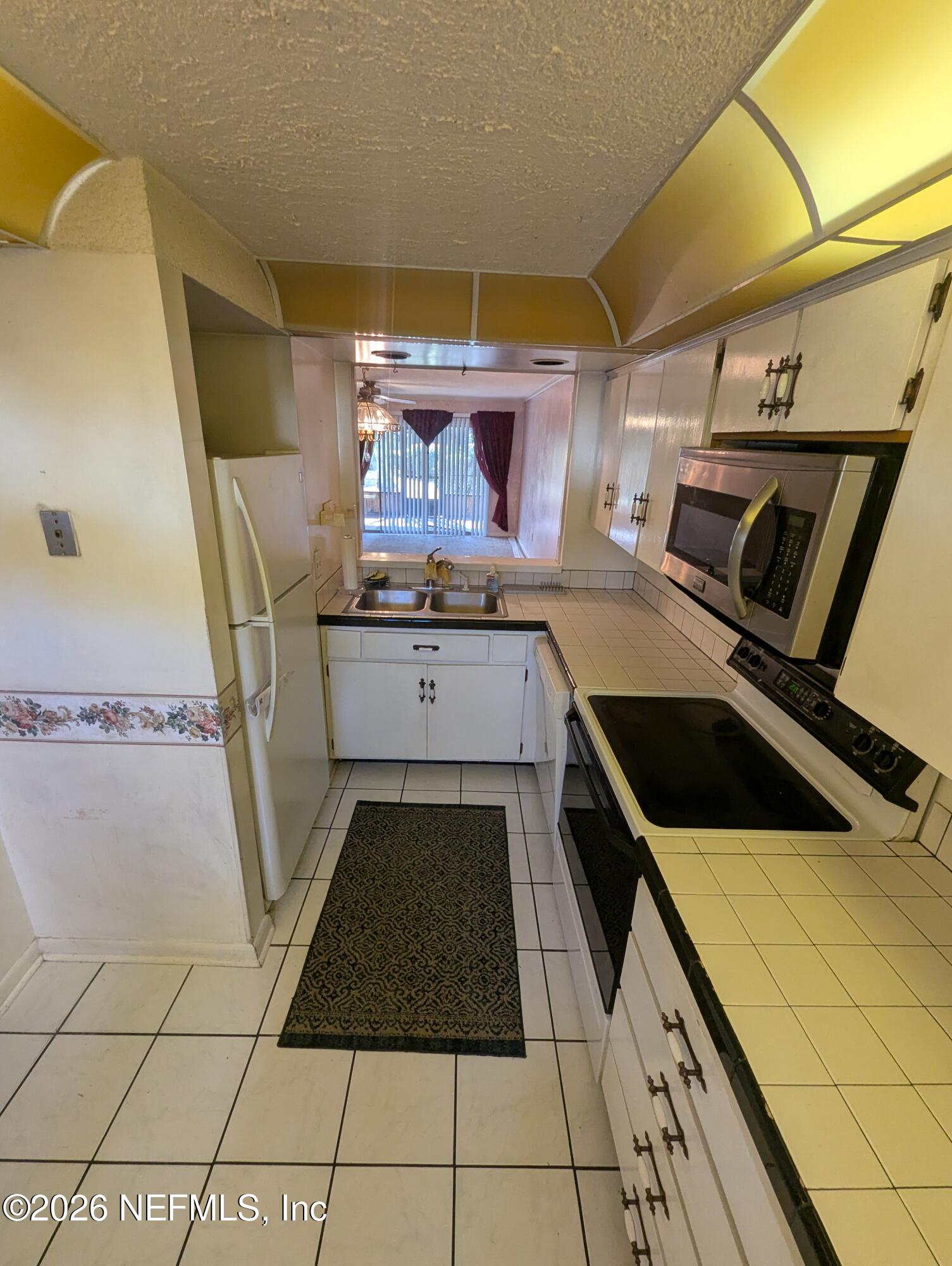 7206 Cypress Cove Road, Unit 14 Jacksonville, FL 32244 - Photo 5 of 23 a kitchen with a sink a stove and cabinets