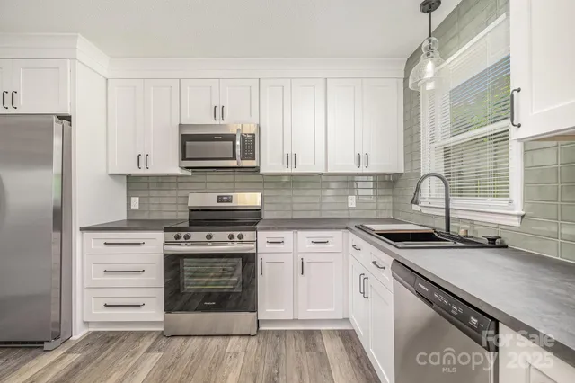 a kitchen with granite countertop a stove sink and cabinets