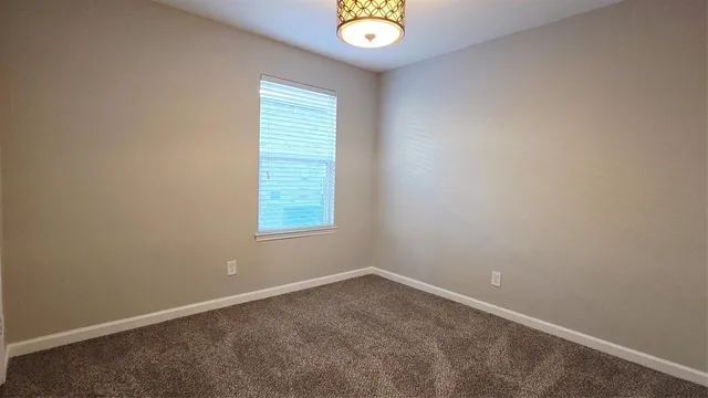 an empty room with window and ceiling fan