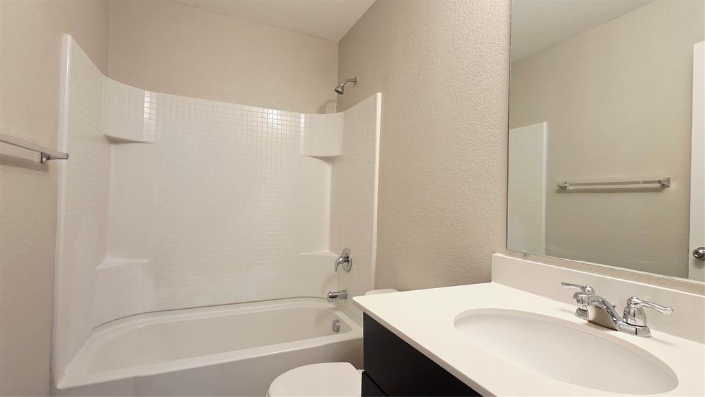 824 Rivers Creek Lane Little Elm, TX 75068 - Photo 18 of 20 a bathroom with a bathtub shower sink vanity and a toilet