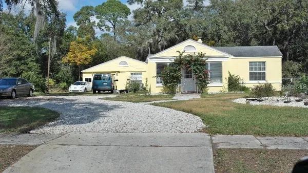 a front view of a house with a yard and trees