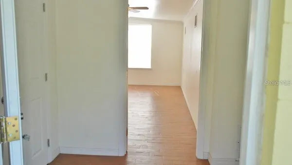 a view of a hallway with wooden floor