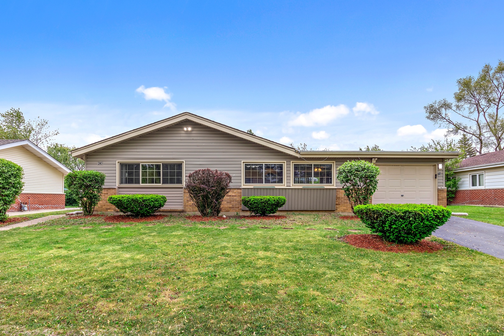 a view of a house with a yard and potted plants