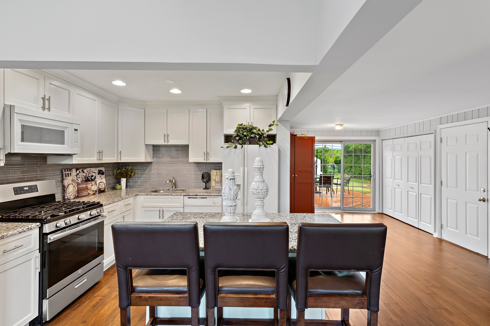 245 Washington Boulevard Hoffman Estates, IL 60169 - Photo 8 of 19 a kitchen with stainless steel appliances granite countertop a stove a refrigerator a kitchen island and chairs with wooden floor