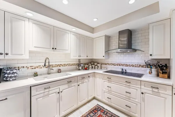 a kitchen with stainless steel appliances granite countertop white cabinets sink and stove
