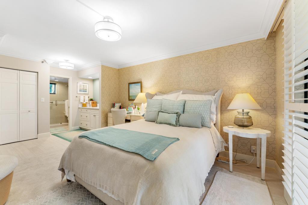200 Ocean Trail Way, Unit T7 Jupiter, FL 33477 - Photo 19 of 46 a spacious bedroom with a bed and a lamp