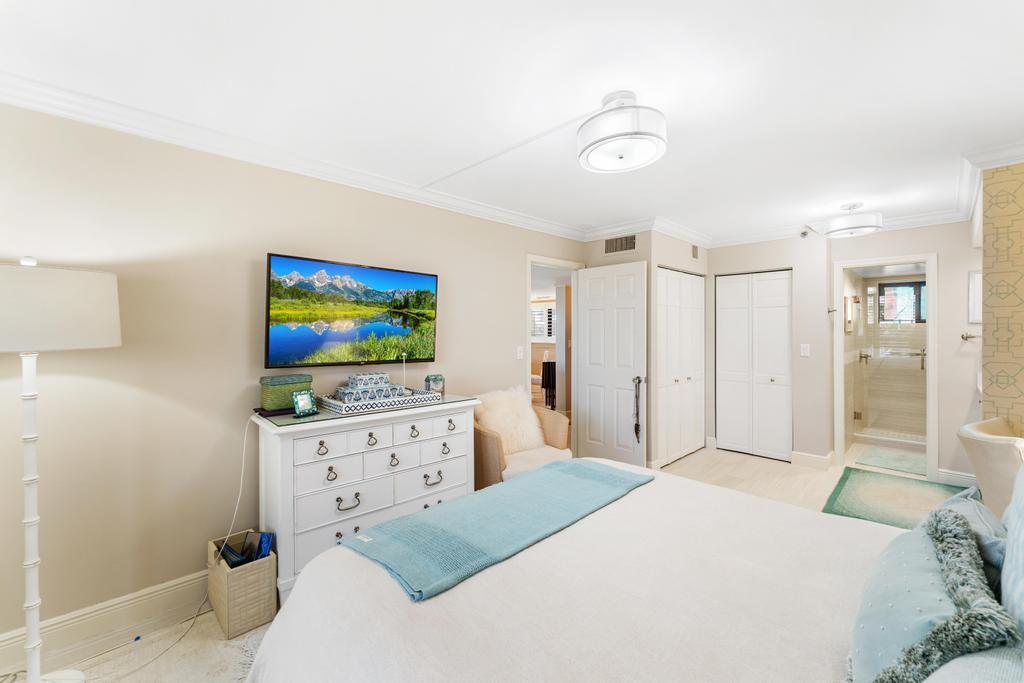 200 Ocean Trail Way, Unit T7 Jupiter, FL 33477 - Photo 21 of 46 a bedroom with a bed and a flat screen tv in it