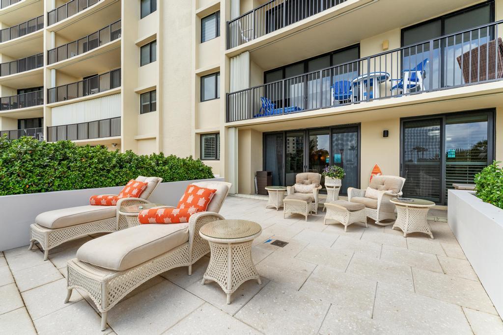 200 Ocean Trail Way, Unit T7 Jupiter, FL 33477 - Photo 33 of 46 a view of a patio with couches table and chairs and potted plants