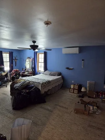 a spacious bedroom with a bed and a chairs