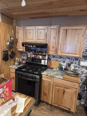 a kitchen with granite countertop a stove sink and cabinets